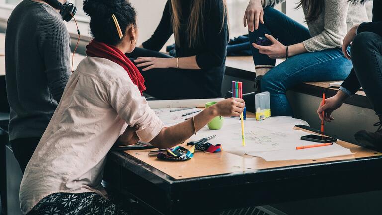 Students gathered around a table working on a group project